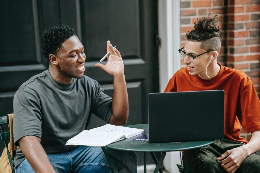 Online students sitting outside with their laptops