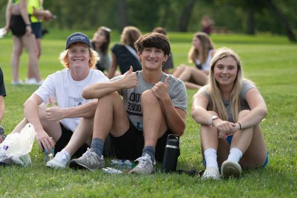 Students sitting on the grass in downtown Midl和 during Welcome Weekend